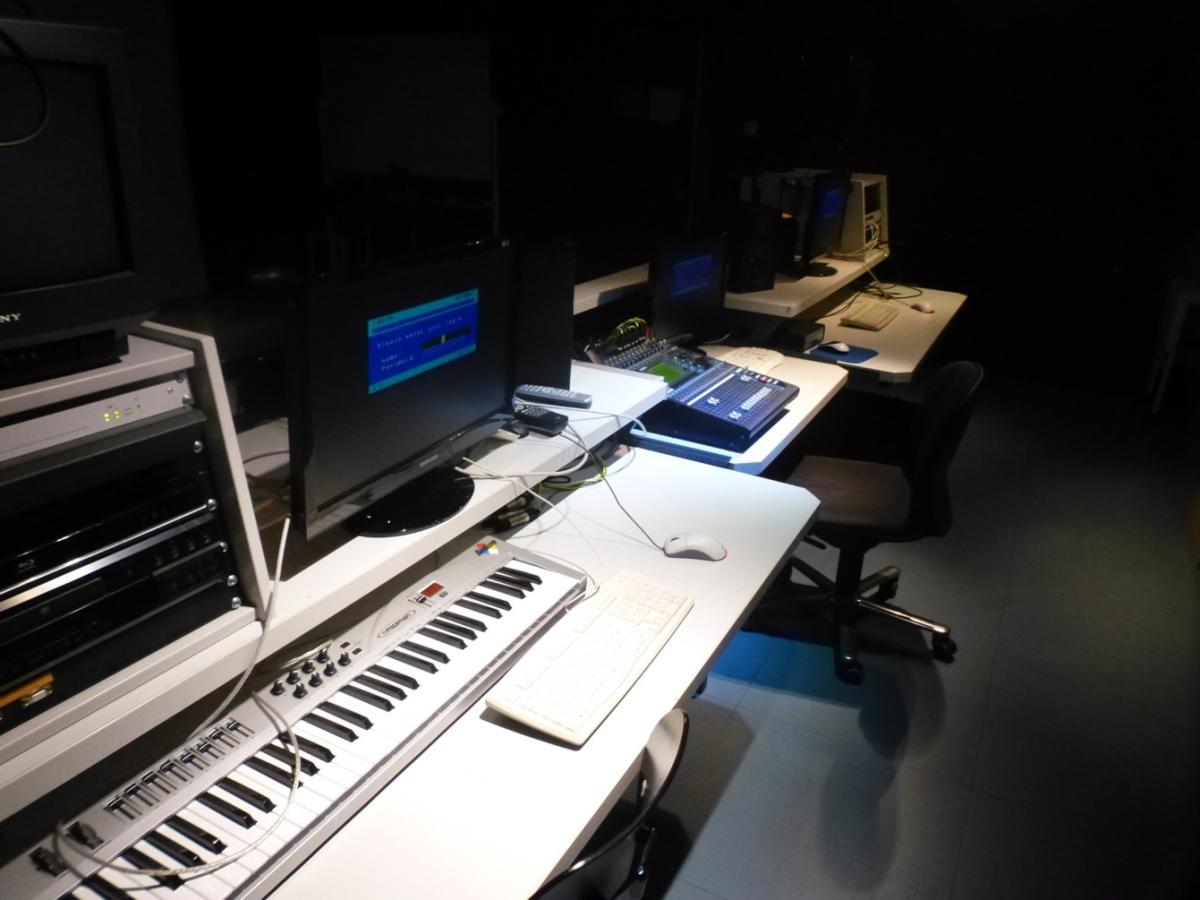 Unterrichtsplatz mit verschiedenen Medieneinheiten, wie Keyboards, Monitoren, Verstärkern.