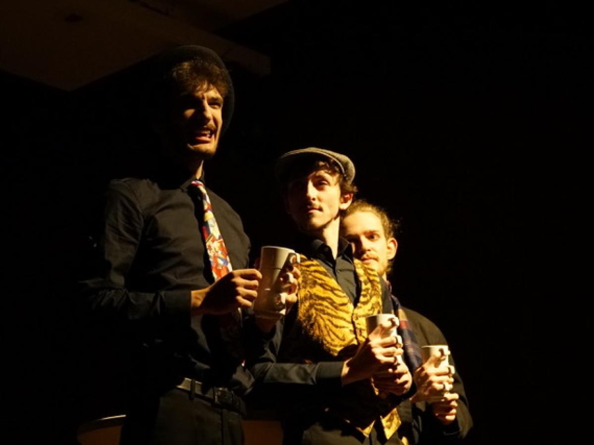 Drei Männer mit je drei Tassen kommunizieren miteinander.