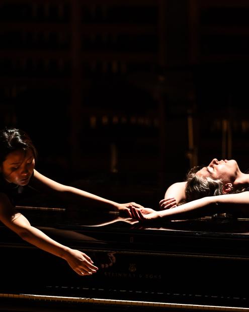 Zwei Studierende der Elementare Musikpädagogik berühren sich über dem Flügeldeckel.