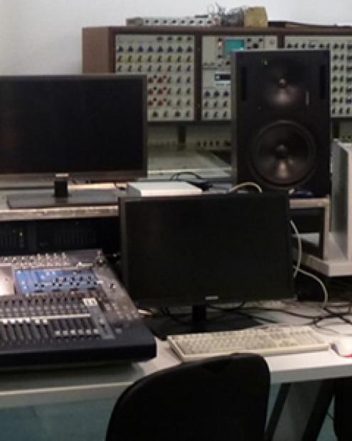 Unterschiedliche Rechner, Verstärker, Monitore und ein Mischpult prägen diesen Arbeitsraum.