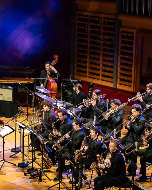 Die Big Band der HMDK Stuttgart unter Leitung von Prof. Rainer Tempel auf dem Konzertsaalpodium.