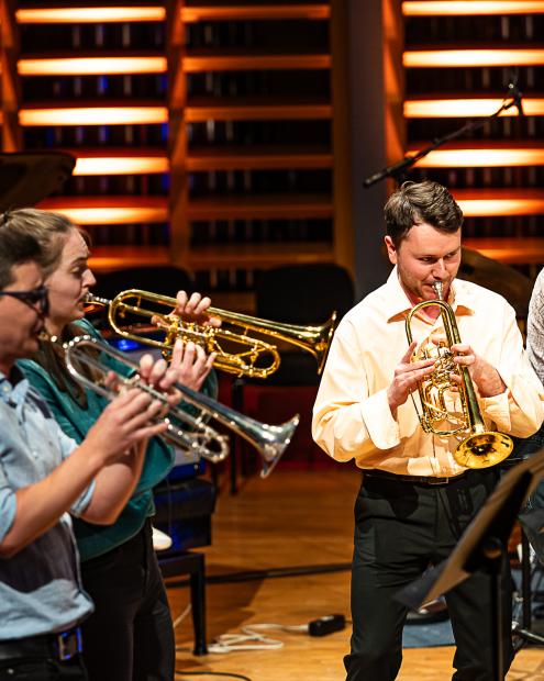 Studierende der Trompetenklassen musizieren auf dem Konzertsaalpodium. Die Studierenden sind leger gekleidet.