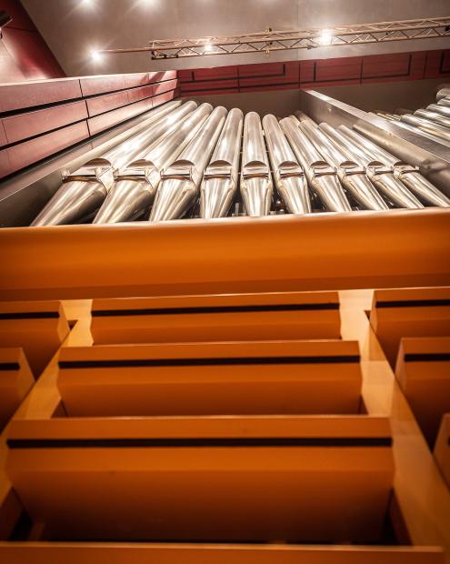 Blick von unten auf die aufgeklappten Orgelschweller und das silberfarbene Orgelprospekt.