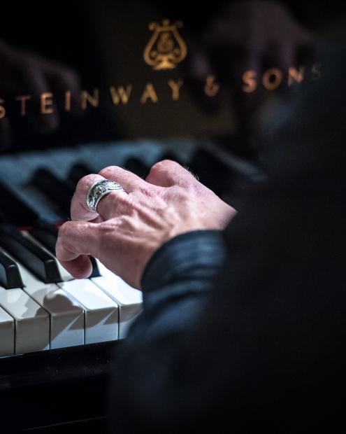 Hand auf Klaviertastatur.