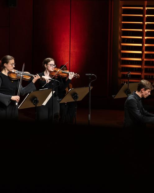 Zwei musizierende Geigerinnen und ein Cembalist auf dem Konzertpodium.
