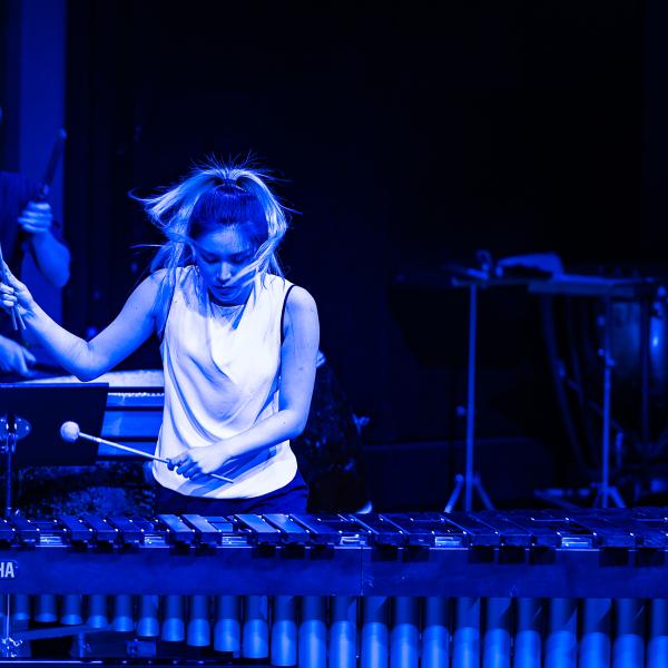 Studentin spielt Vibraphone in blauem Licht.