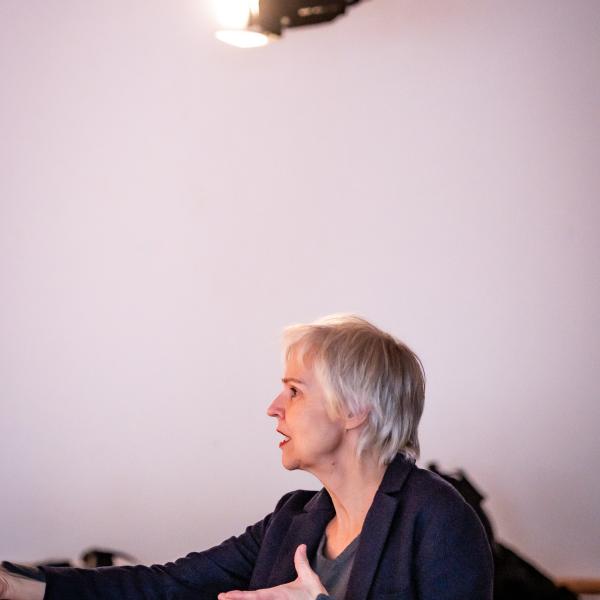 Frau gestikuliert und spricht.