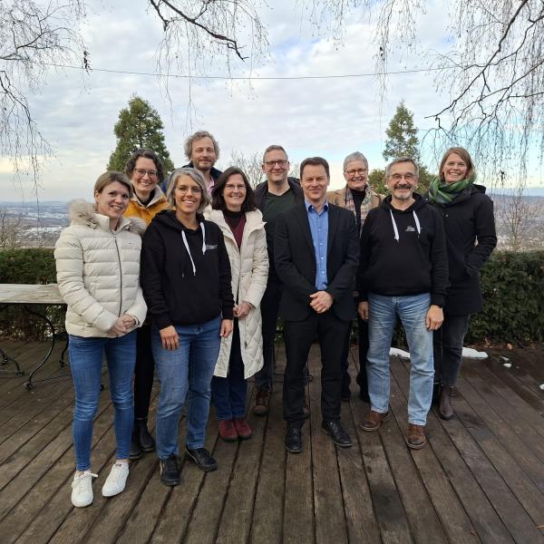 Teamgruppenfoto auf der Terrasse vom Landgut Burg. Im Hintergrund mit dem Blick auf die Rems-Murr-Region.