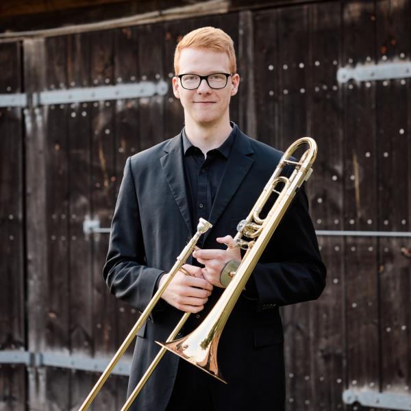 Portrait des Studenten Jonathan Böhm mit seienr Posaune in der Hand.