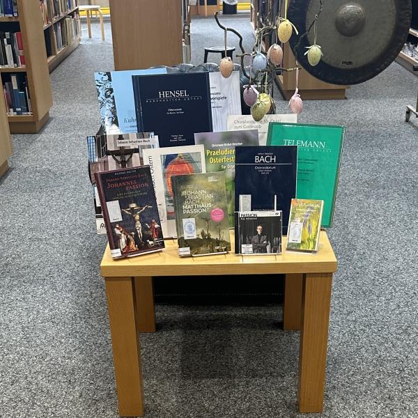 Das Bild zeigt Bücher und Noten zum Thema Ostern und Passionszeit, die auf einem Tisch in der Bibliothek der HMDK stehen.
