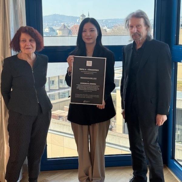 Die Förder des Vereins Triple A mit einer Studentin und ihrer Urkunde.
