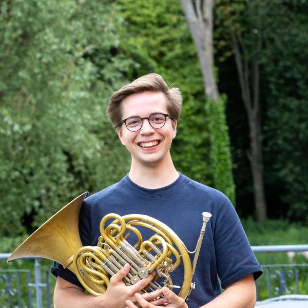 Portrait von Samuel Gassert mit Horn im Arm