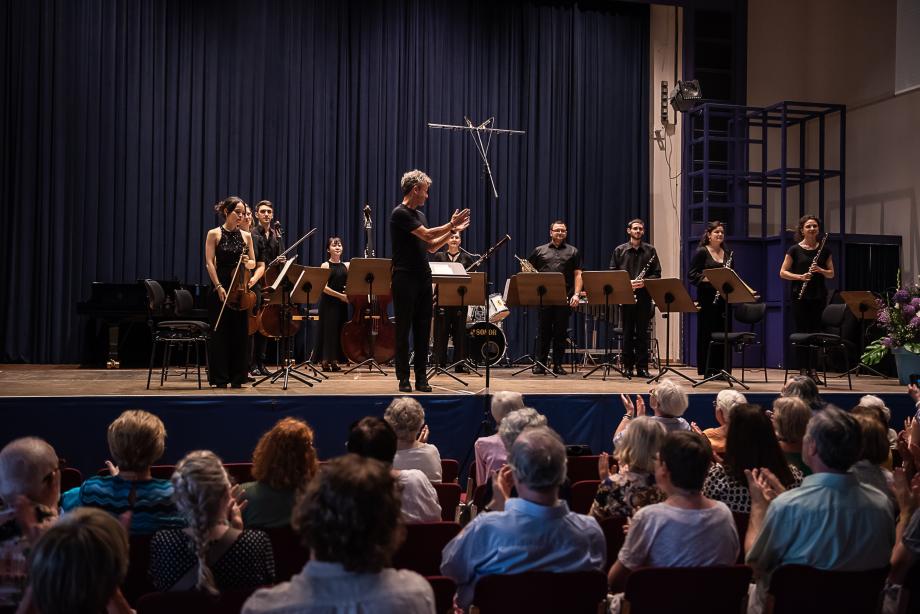 Studierende und Prof. Marc Engelhardt auf der Bühne. Das Publikum applaudiert.