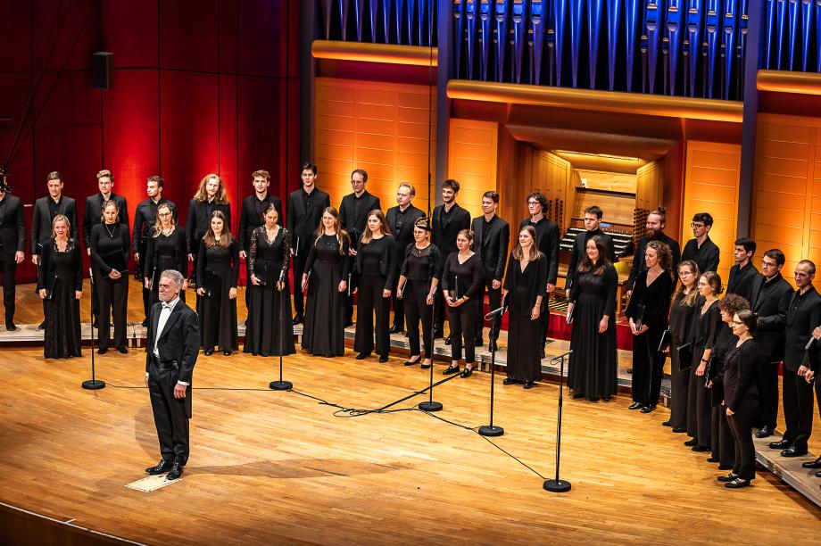 Der Kammerchor der HMDK in zweireihiger, halbrunder Aufstellung vor dem Konzertorgel.