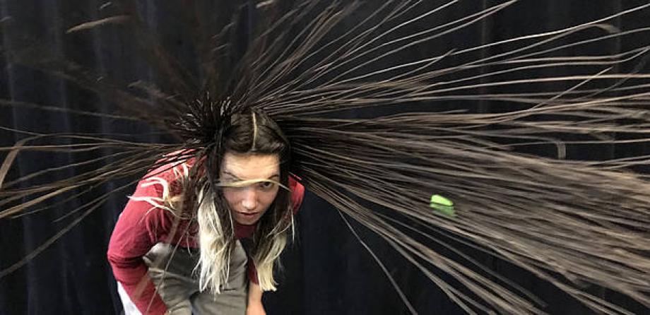 Frau schleudert ihre Haare, die aus Weidenruten sind herum.