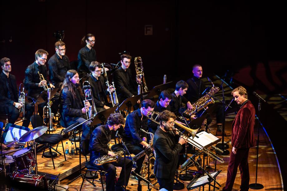 Die Big Band mit Saxophonsolisten und unter der Leitung von Prof. Rainer Tempel auf dem Konzertsaalpodium der HMDK. 