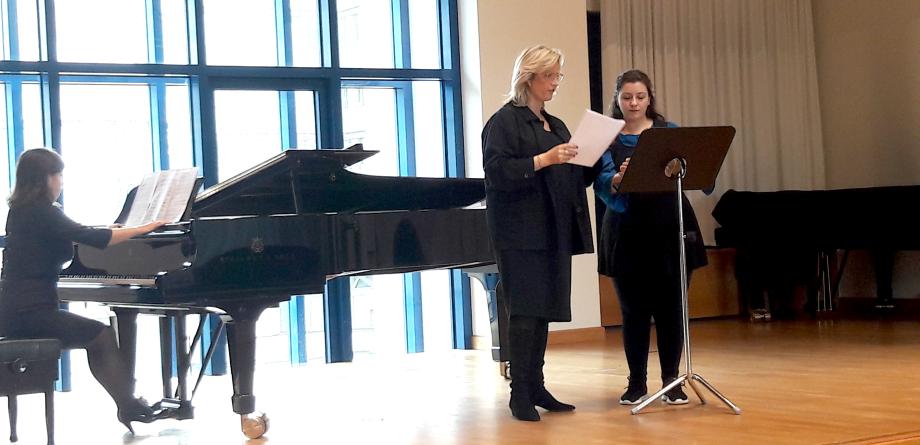 Meisterkurs Gesang 2019: Eien Pianistin am Flügel, zwei Studierende mit Noten am Notenständer.