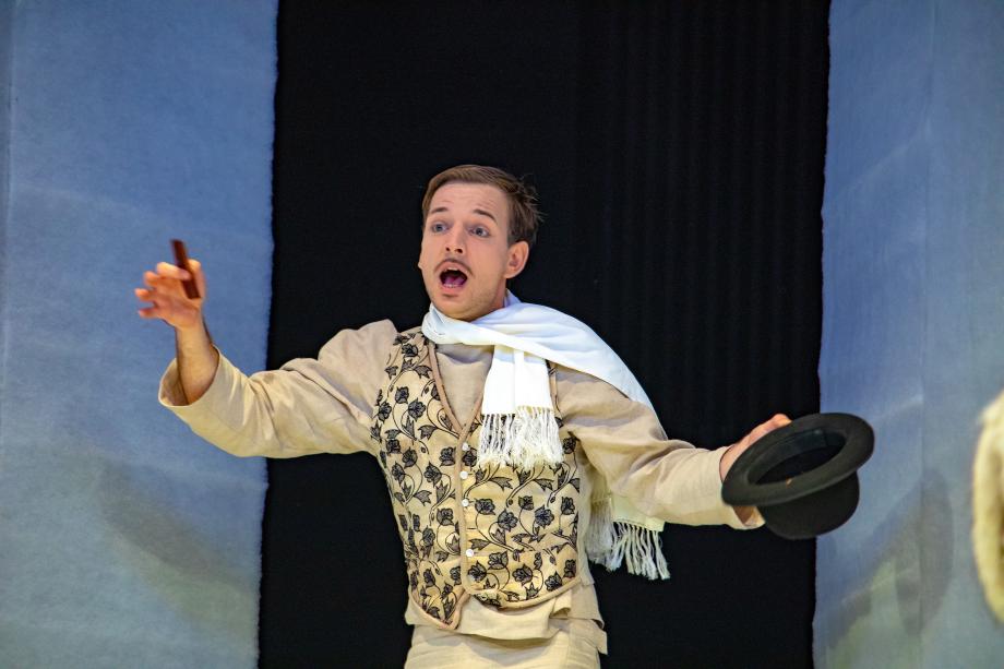 Mann ruft mit Melone und Kamm in der Hand. Er ist edel gekleidet.