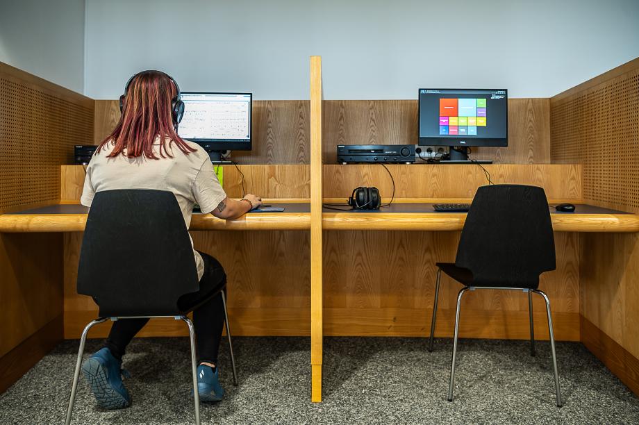 Auf dem Bild sind zwei Arbeitsplätze mit Computern und Medienausstattung zu sehen.