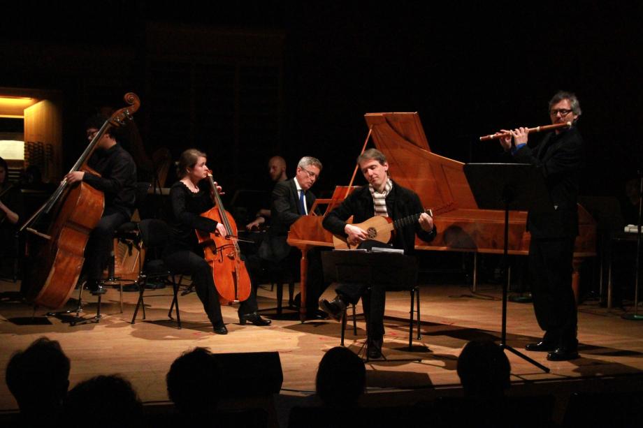 Kammerensemble auf dem Konzertpodium. Im Vordergrund musiziert der Gitarrist Johannes Monno.