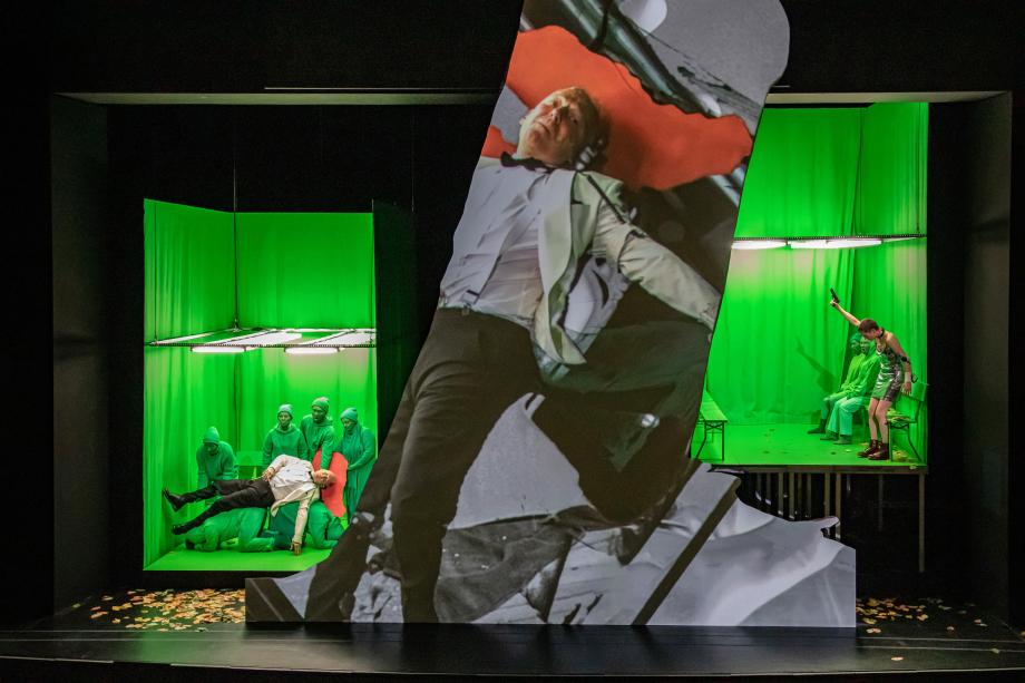 Älterer Herr liegt auf den Knien von vier grünen Männern, nachdem er von einer Person erschossen wurde.