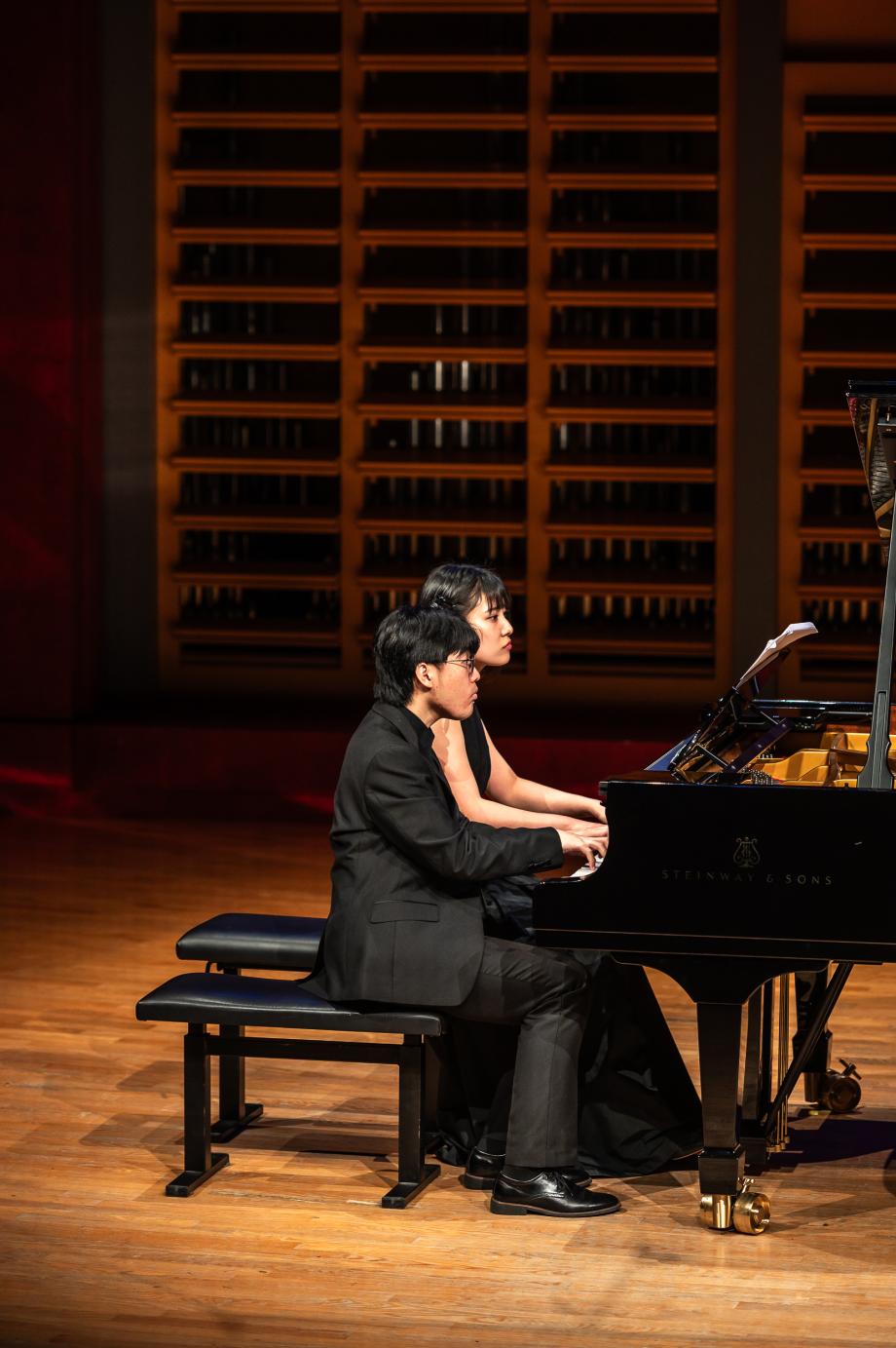 zwei Studierende an einem Flügel.