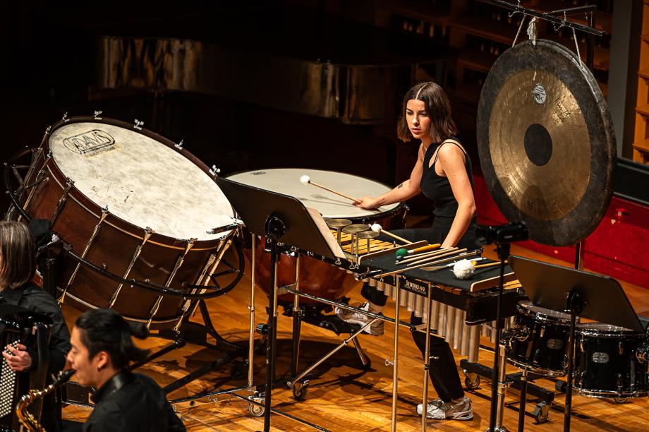 Studierende der Schlagzeugklasse sitzt in einem vielfältigen Setup aus Schlagzeuginstrumenten.