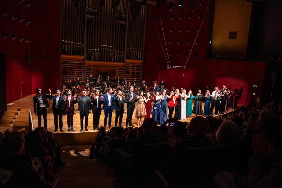 Studierende stehen am Bühnenrand zum Schlussapplaus.