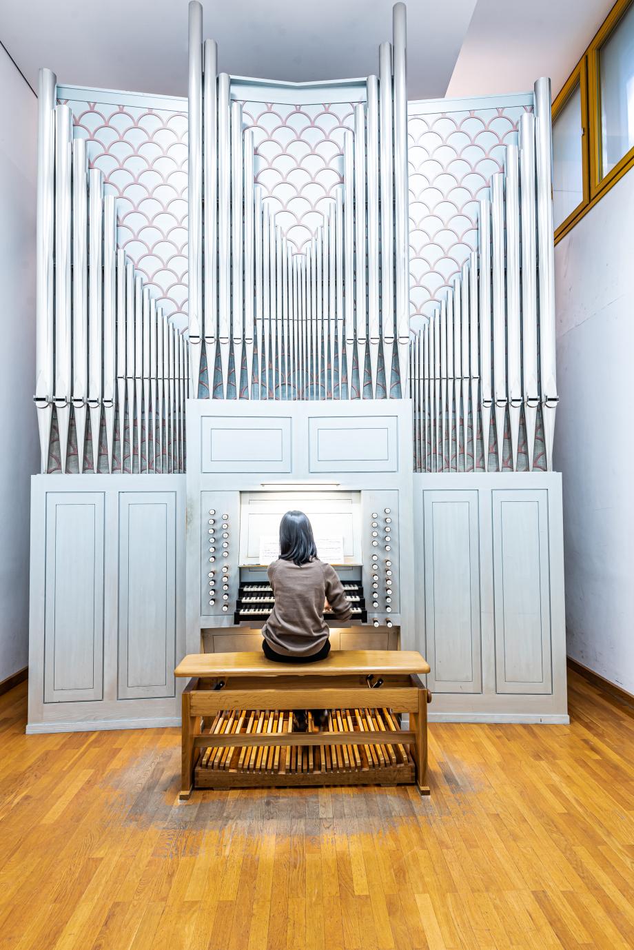 Studentin spielt an einer romantischen Orgel.
