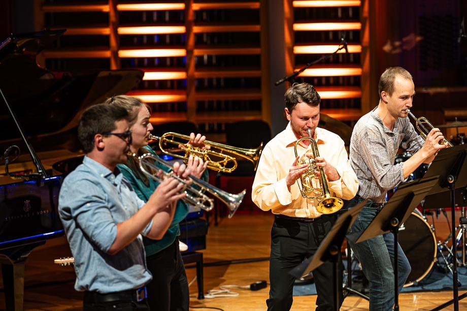 Studierende der Trompetenklassen musizieren auf dem Konzertsaalpodium. Die Studierenden sind leger gekleidet.
