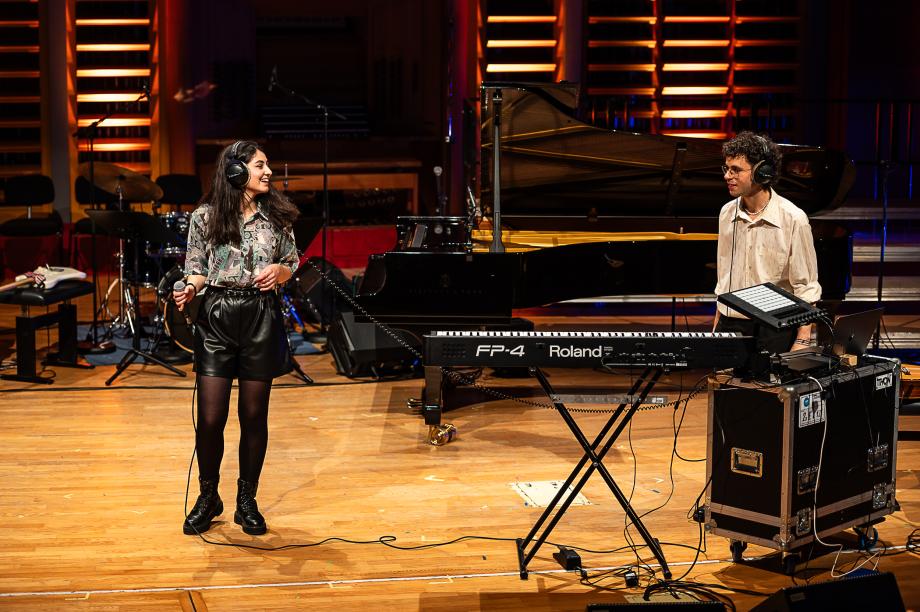 Schulmusikkonzert 2023: Studentin am Mikrophone, Student am E-Piano.