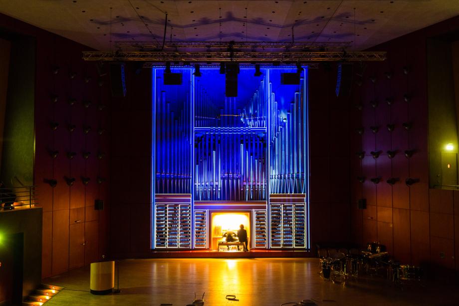 Beleuchtete Orgel im dunklen Konzertsaal.