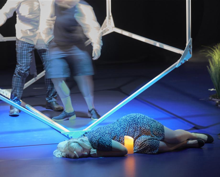 Studentin liegt am Boden vor einer brennenden Kerze.