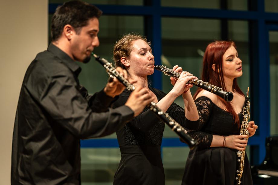Drei Oboenstudierende beim Musizieren auf der Bühne des Orchesterprobenraums.