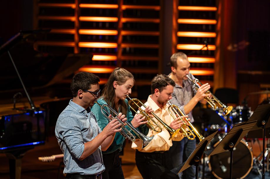 Vier Trompeten-Studierende im Konzertsaal.