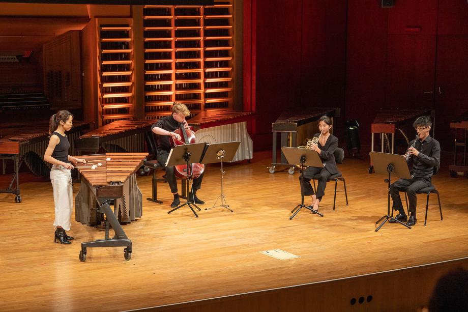 Quartettformation mit Schlagzeugstudentin im Konzertsaal.