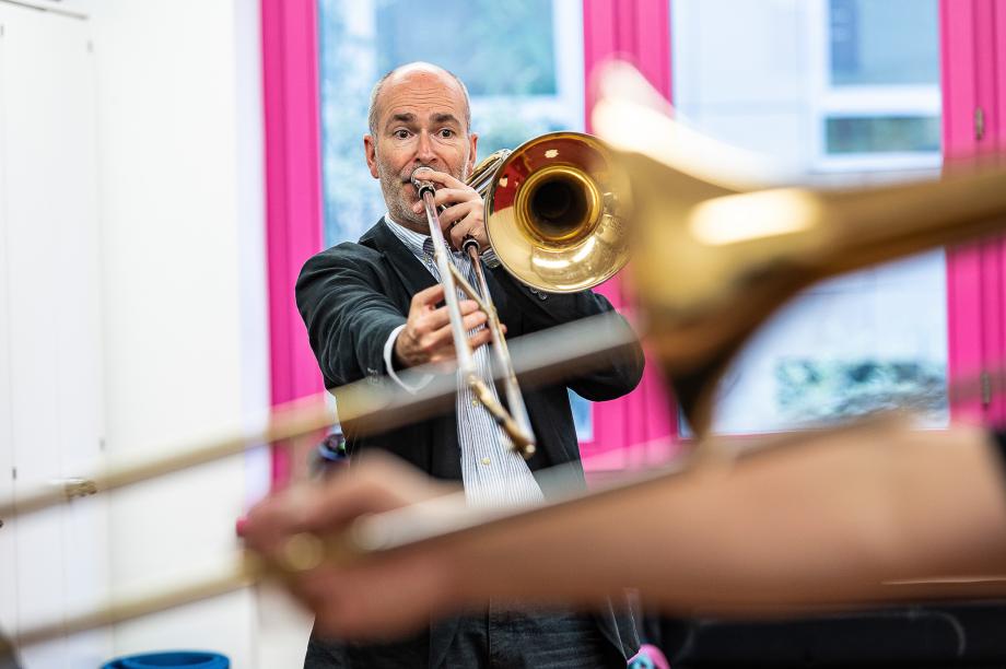 Posaunenprofessor Henning Wiegräbe in einer Unterrichtssituationen. Er ist von vorne abgebildet, vom Studierenden sieht man nur das Instrument.