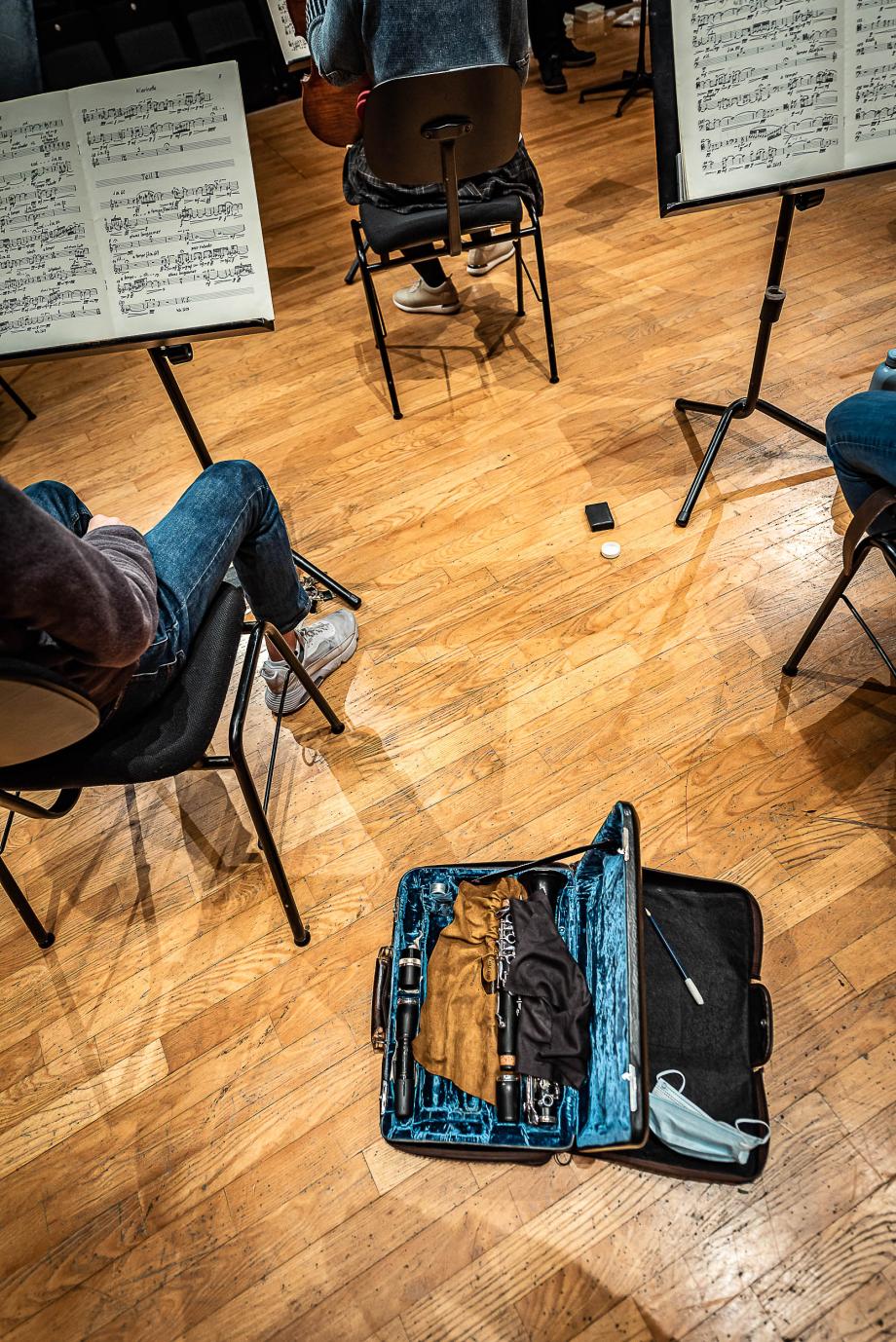 Blick aus der Perspektive eines Musikers. Studierende und Notenpulte mit jeweiligen Partituren sind zu sehen.