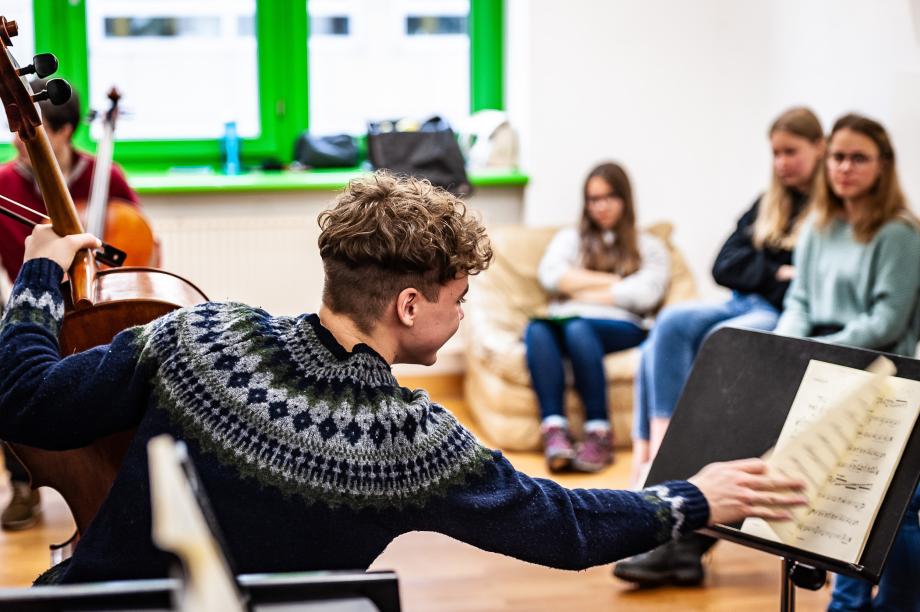 Offener Cellounterricht mit Prof. Tristan Cornut beim Studieninforamtionstag. An der Seite sitzen interessierte Schülerinnen und SChüler.