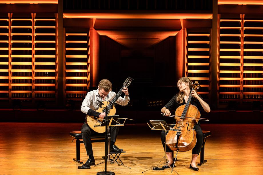 Gitarren-Celloduo konzertiert auf dem Podium.