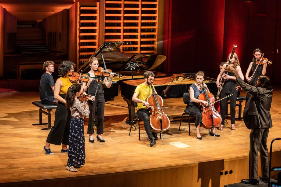 Musizierendes Kammerensemble auf dem Podium. Prof. Dr. Noam Sivan dirigiert das Ensemble.