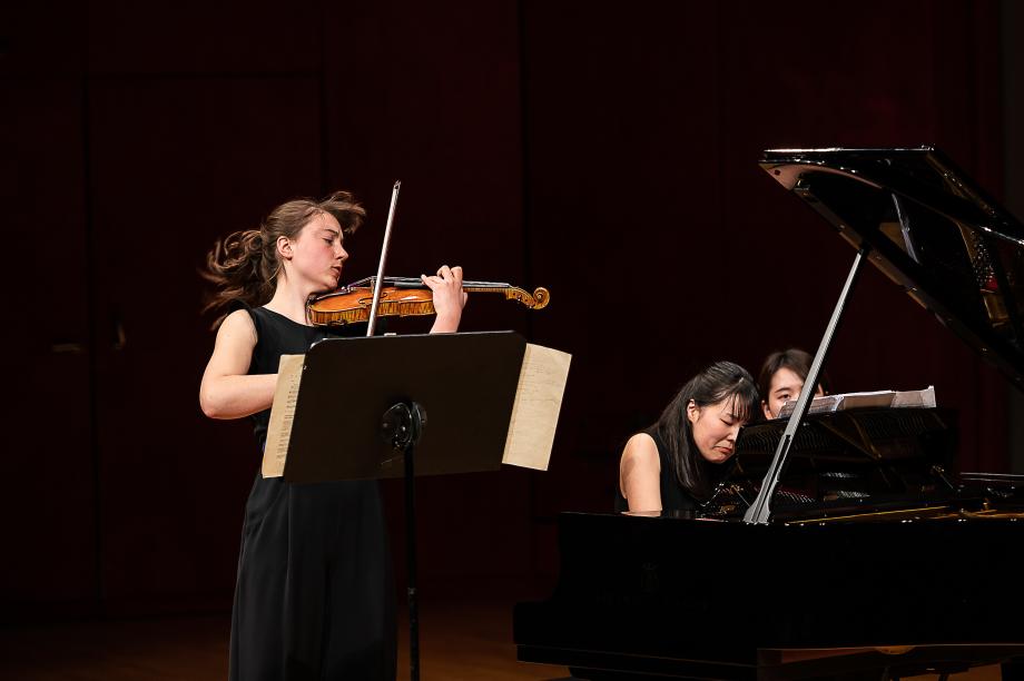 Studentisches Violin-Klavierduo auf dem Konzertsaalpodium.