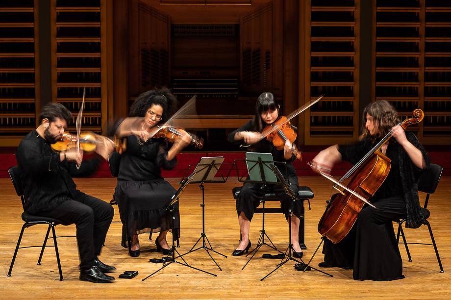 Musizierendes Kahlo-Quartett. Durch die längere Belichtungszeit werden die letzten Bogenbewegungen sichtbar.