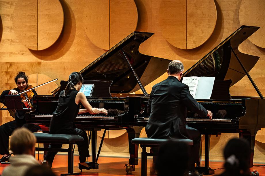 Rückenansicht beim vierhändigen Musizieren an zwei Flügeln mit Prof. Florian Wiek und einer Studentin im Stuttgarter Hospitalhof.