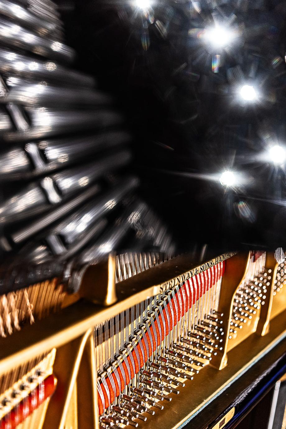 Detailaufnahme des Flügels, wo durch die Reflektion des Flügeldeckels die unterschiedlichen Beleuchtungskörper der Decke zu sehen sind.