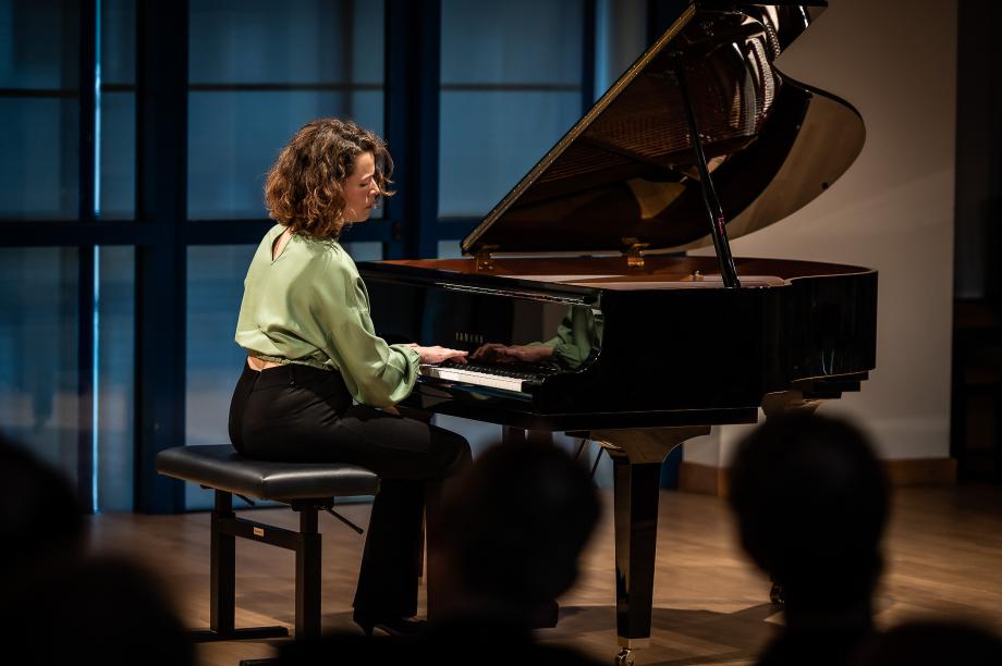 Portraitaufnahme von Silvia Molan am kleinen Sirius-Flügel im Orchesterprobenraum. 