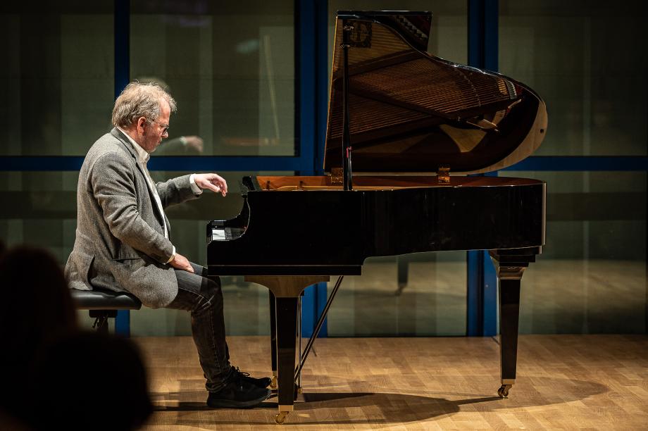 Portraitaufnahme von Prof. Hubert Nuss am kleinen Sirius-Flügel im Orchesterprobenraum.