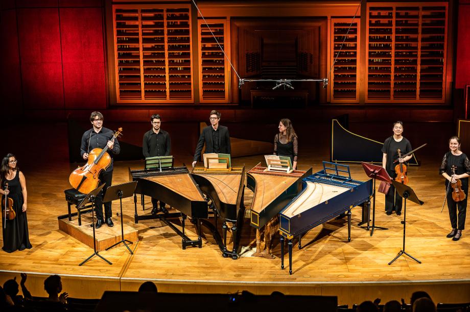 Studierende mit Cembali und Streichinstrumenten.