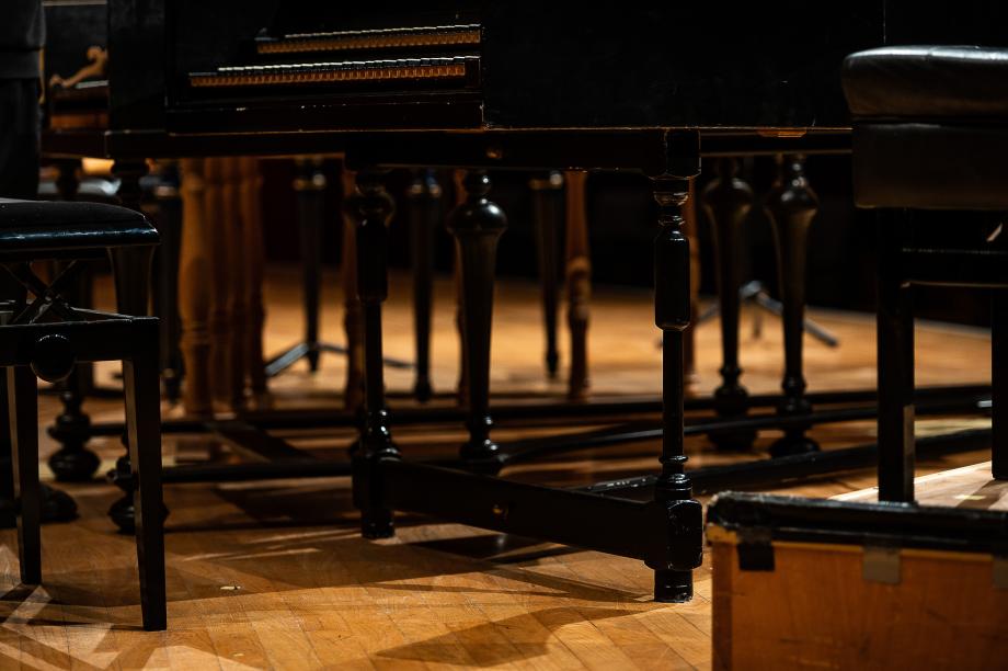 Detailaufnahme von den Cembalobeinen, die auf dem Konzertsaalpodium stehen.
