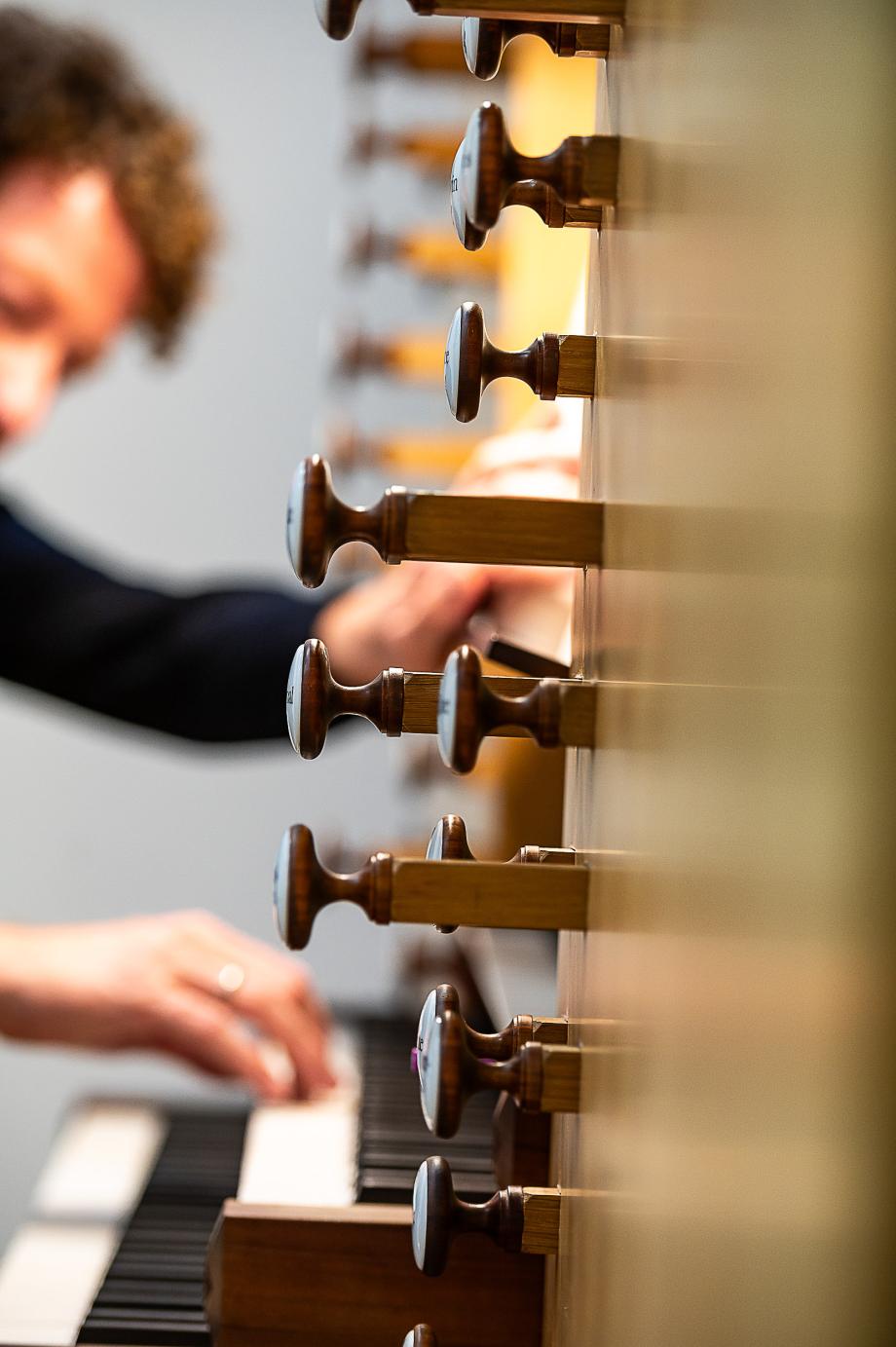 Detailaufnahme von den Registern der Gollorgel. Im Hintergrund ist Orgelprofessor Jörg Halubek schemenhaft zu erkennen.